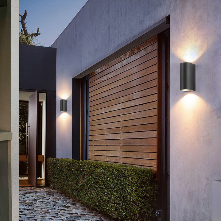 Moderne, enkel, vanntett vegglampe med 2 lyskilder laget av aluminium og glass i sylindrisk design for utendørs bruk.