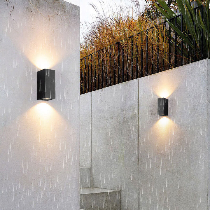 Moderne, enkel, vanntett vegglampe med 2 lyskilder laget av aluminium og glass i sylindrisk design for utendørs bruk.