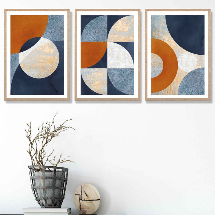 Abstrakt geometrisk sett med 3 innrammede kunsttrykk i marineblått, oransje og gull