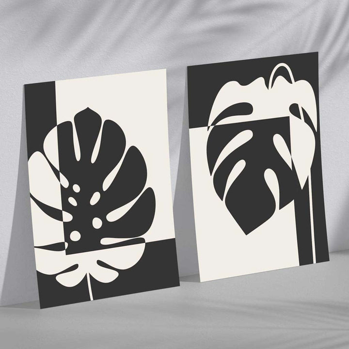 Sett med 2 innrammede kunsttrykk med Monstera-motiver i svart og beige