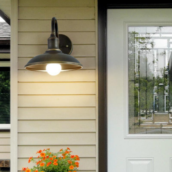 Rund, lokkformet vegglampe med buet jernskjerm og enkeltflammedesign for terrassen
