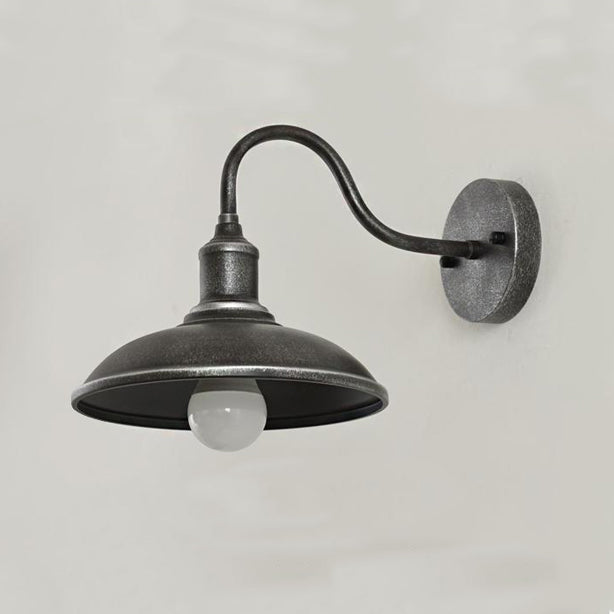 Rund, lokkformet vegglampe med buet jernskjerm og enkeltflammedesign for terrassen