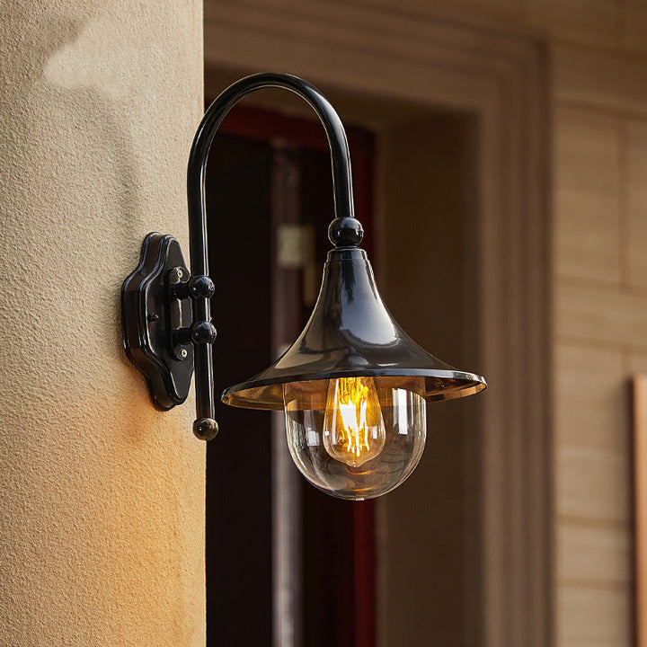 Moderne, enkel vegglampe i aluminium med trompetskjerm og glass, én lyskilde, for utendørs bruk, egnet for hagen.