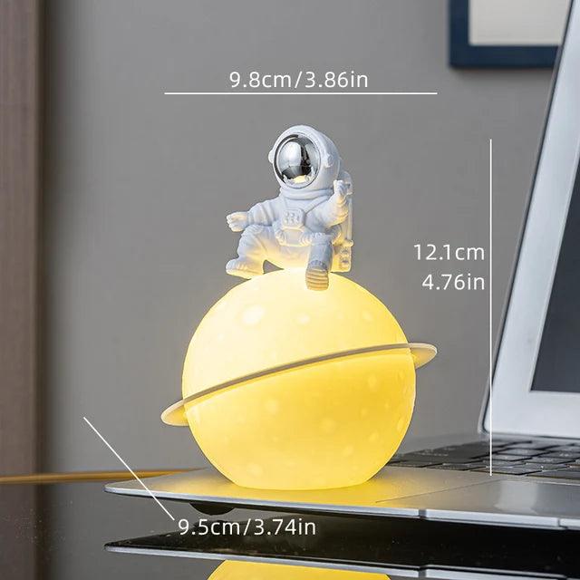 Skanto | AstroLume Astronaut Skulptur med Planet Nattlys | Moderne Dekorativt Høydepunkt | Miljøvennlig PVC & ABS | 9.8 x 12.1 cm