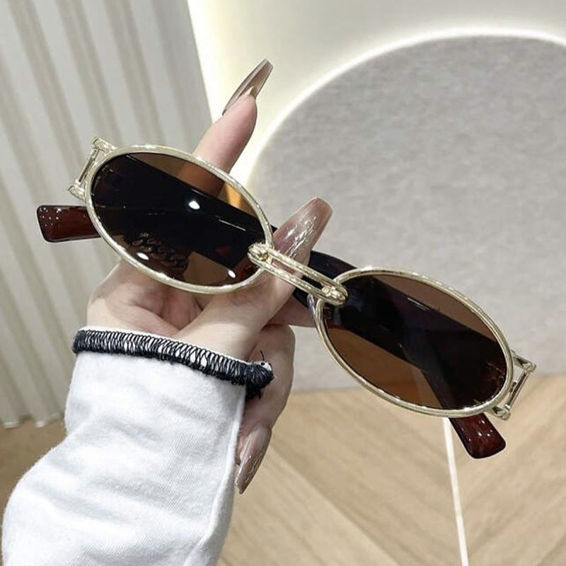 Dame ovalformet solbrille med gullige accenter og stilig ramme Skanto