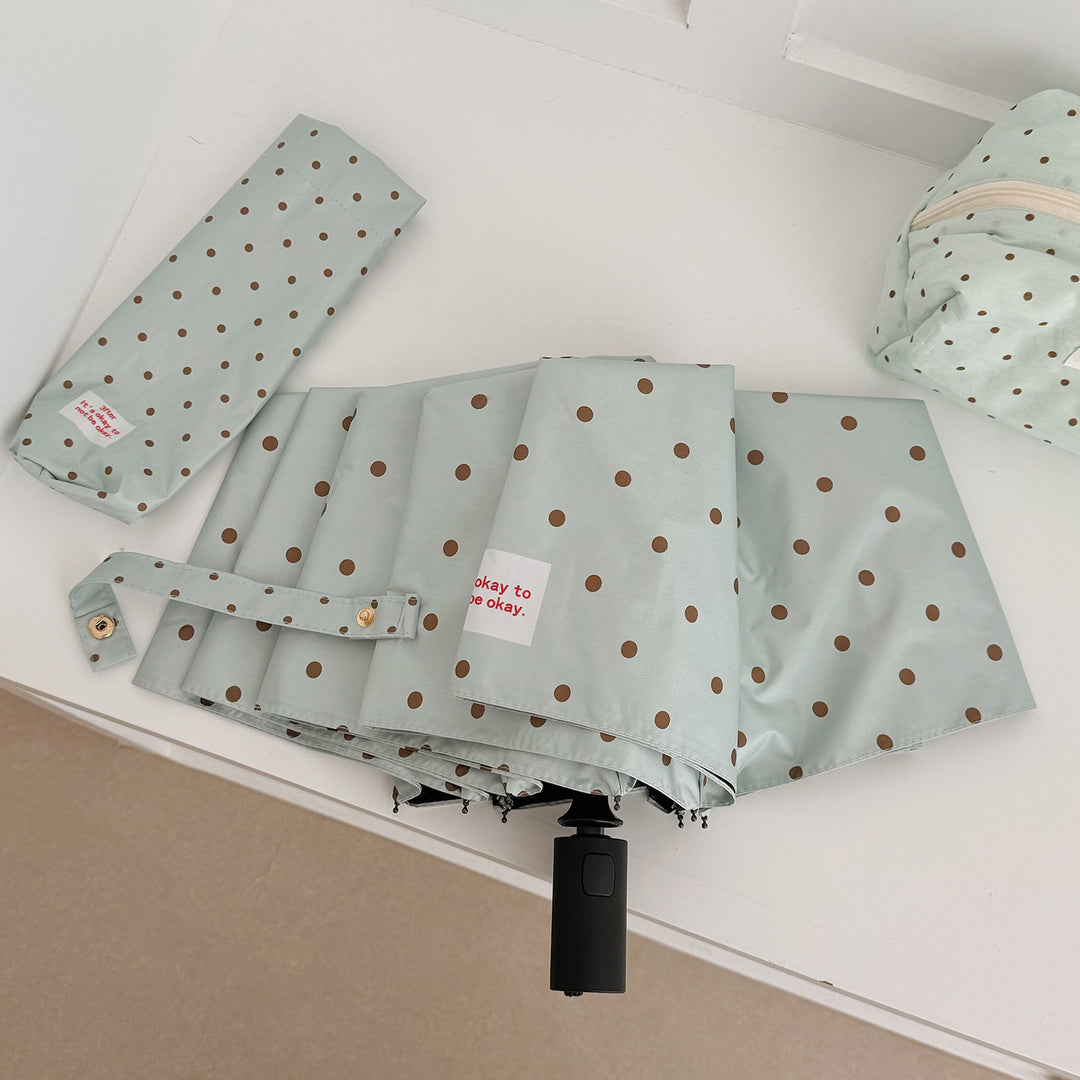 Dame sammenfoldbar paraply med praktisk knappmekanisme og stilfull prikkedesign Skanto