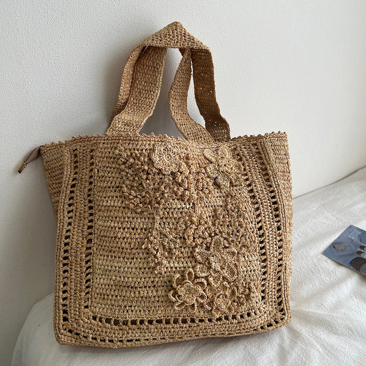 Håndlaget stråveske med blomsterdetaljer Skanto