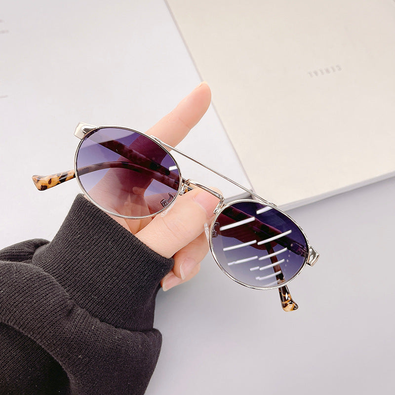 Dame moteriktig solbrille i stilfullt rundt design med gull aksenter Skanto
