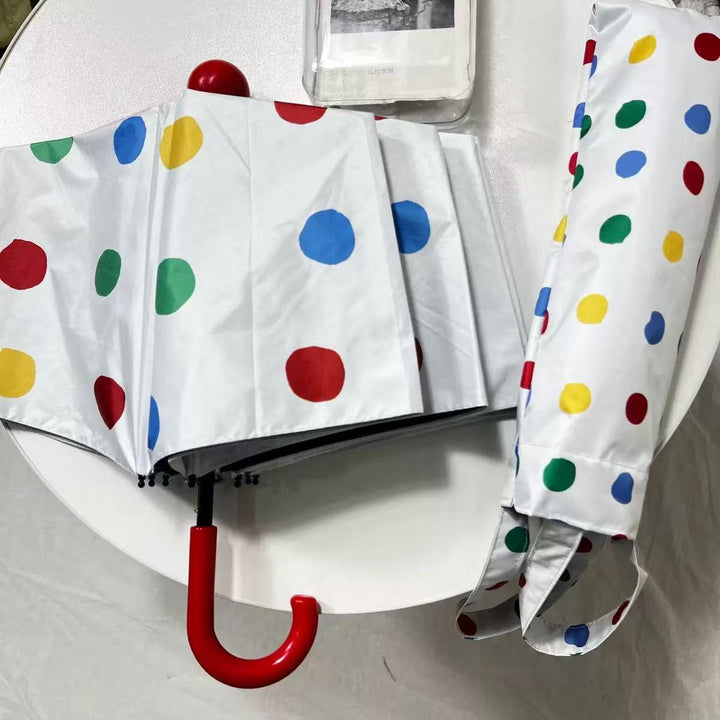 Dame designer Faltregnese med fargerikt prikkemønster Skanto