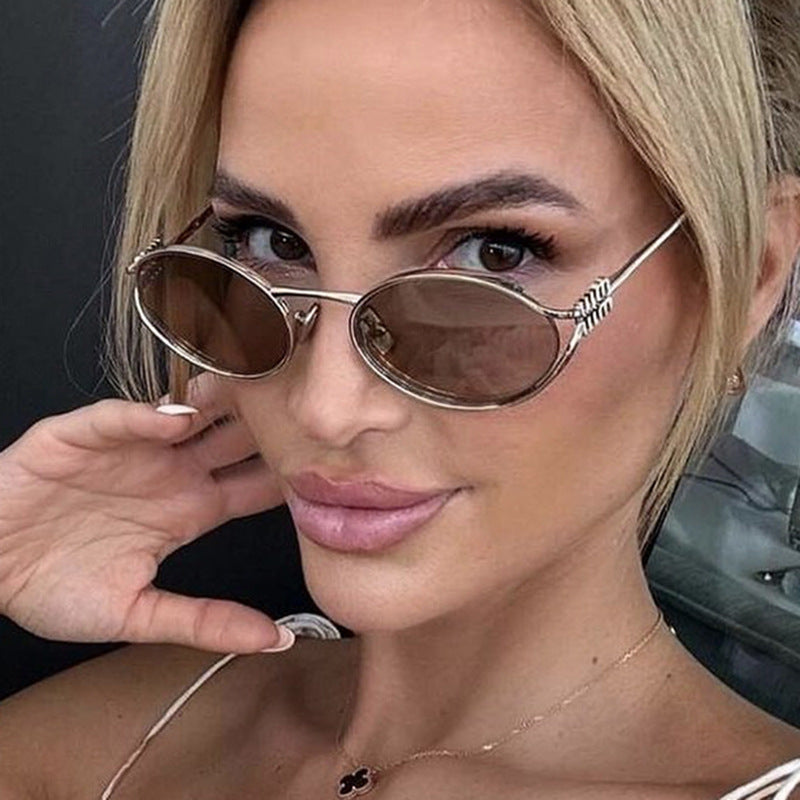 Dame ovalformet solbrille med elegant metallramme og moderne design Skanto