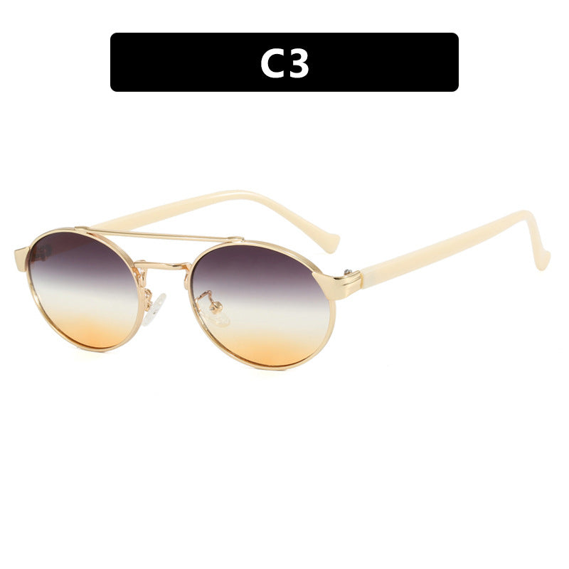 Dame moteriktig solbrille i stilfullt rundt design med gull aksenter Skanto