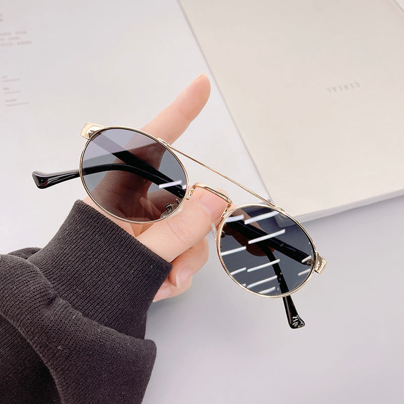 Dame moteriktig solbrille i stilfullt rundt design med gull aksenter Skanto