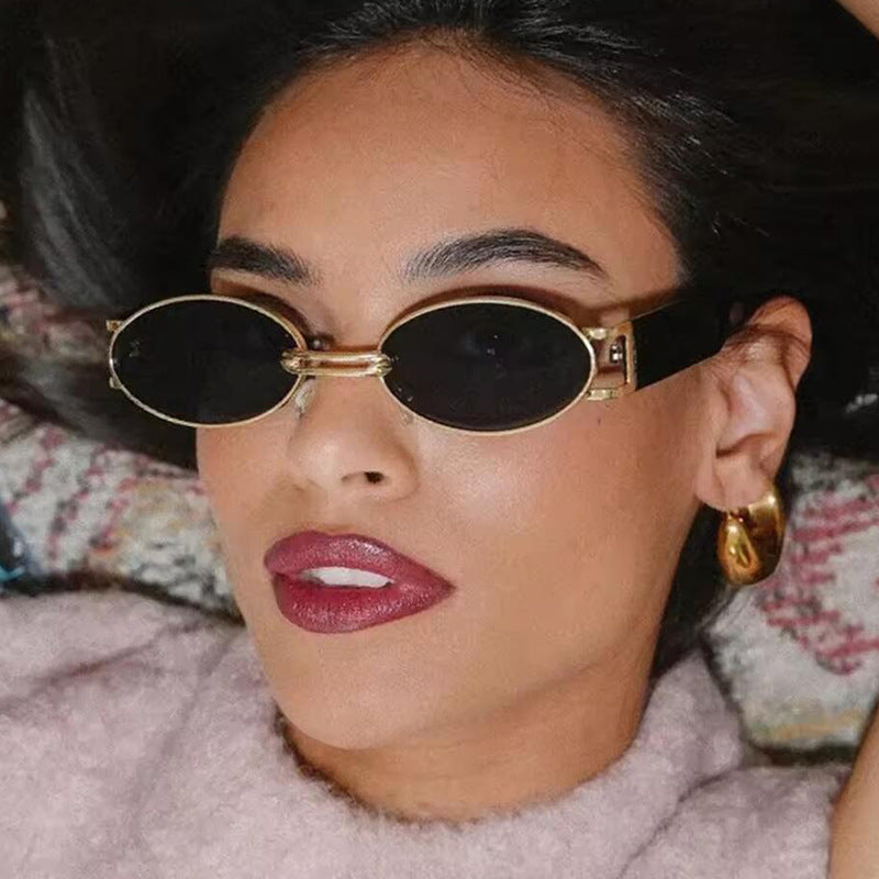Dame ovalformet solbrille med gullige accenter og stilig ramme Skanto