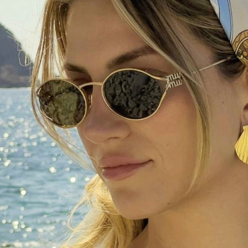Dame ovalformet solbrille med elegant metallramme og moderne design Skanto