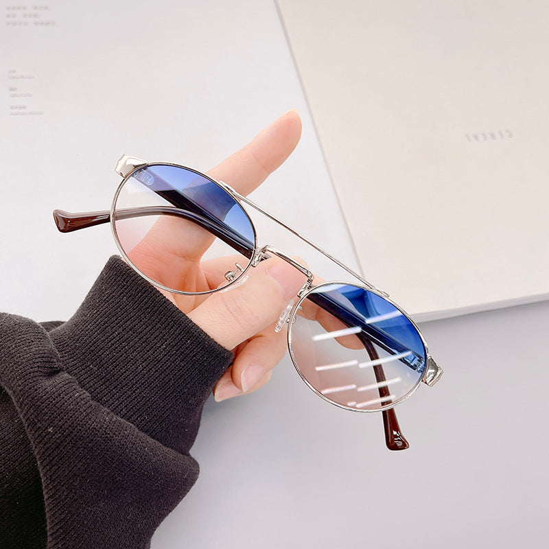 Dame moteriktig solbrille i stilfullt rundt design med gull aksenter Skanto