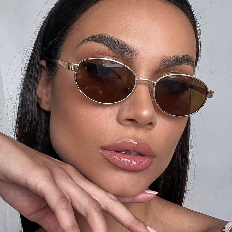Dame moteriktig solbrille i elegant oval design med ramme i høykvalitets metall Skanto