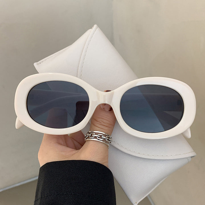 Dame moteriktig solbrille i elegant ovalt design med robust ramme Skanto