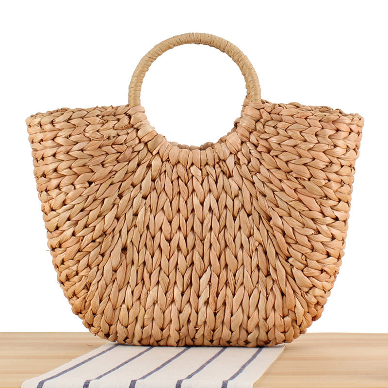 Woven natural material handbag with elegant round handle Skanto