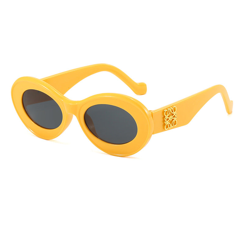 Dame moteriktig solbrille med oval ramme og gullapplikasjoner Skanto