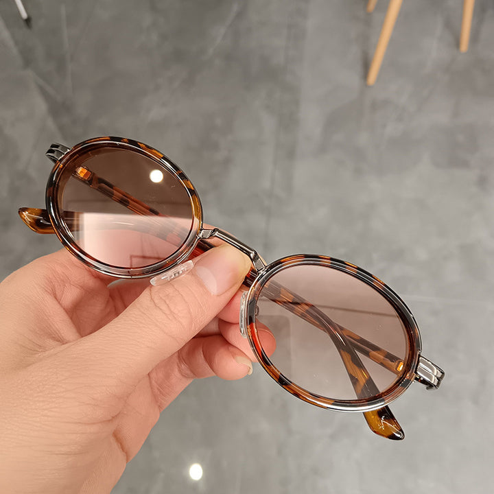 Dame rund solbrille med lette glass og gyldne detaljer Skanto