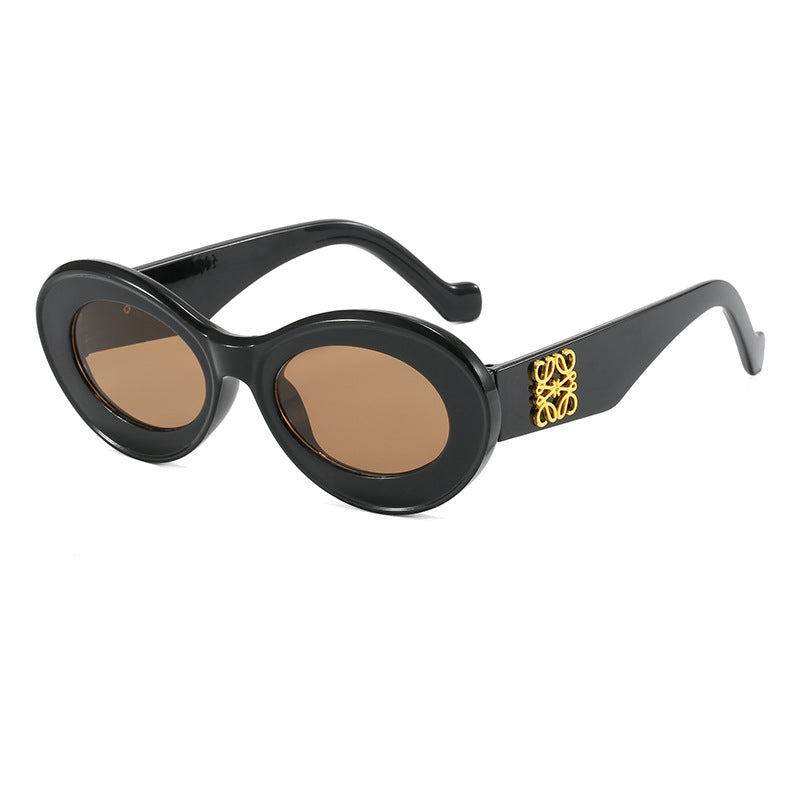 Dame moteriktig solbrille med oval ramme og gullapplikasjoner Skanto