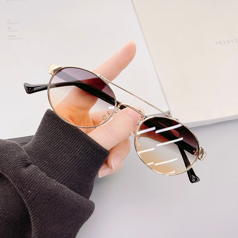 Dame moteriktig solbrille i stilfullt rundt design med gull aksenter Skanto