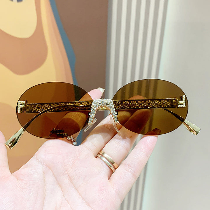 Dame solbrille med glitrende ramme og ovale glass Skanto