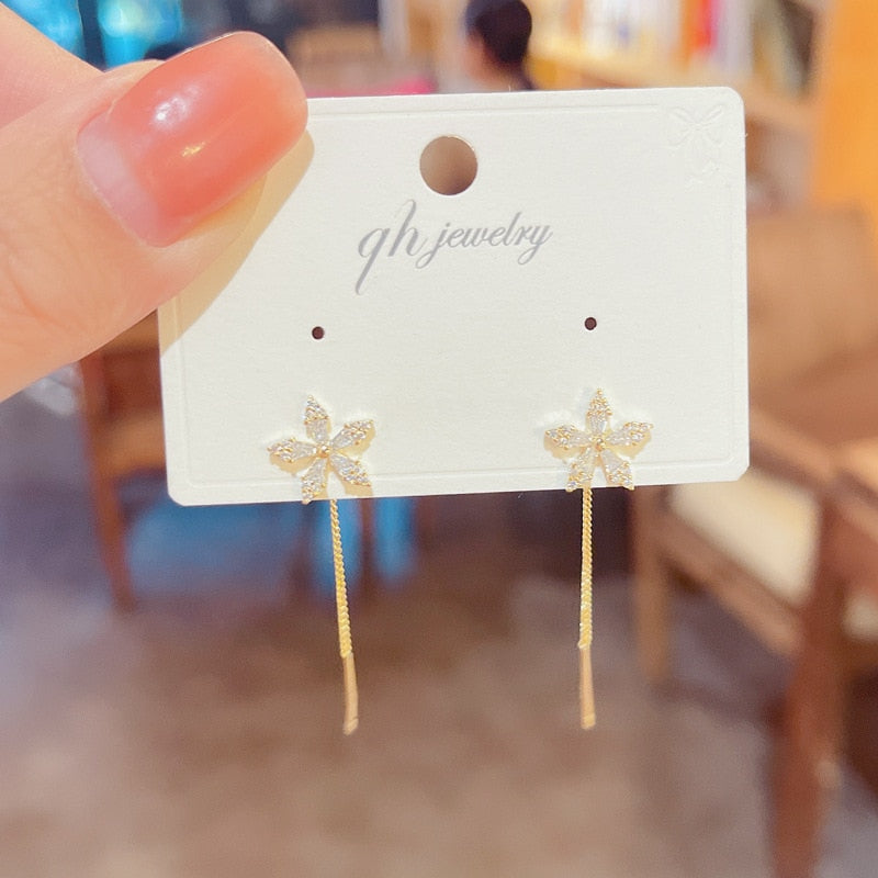 Skanto | Lange Blumen-Kettenohrringe | Elegantes leichtes Hängedesign | Gold
