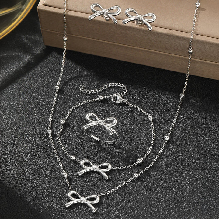 Skanto | Feminine Bow Satellite Chain Necklace, Bracelet, Earrings, and Ring Set