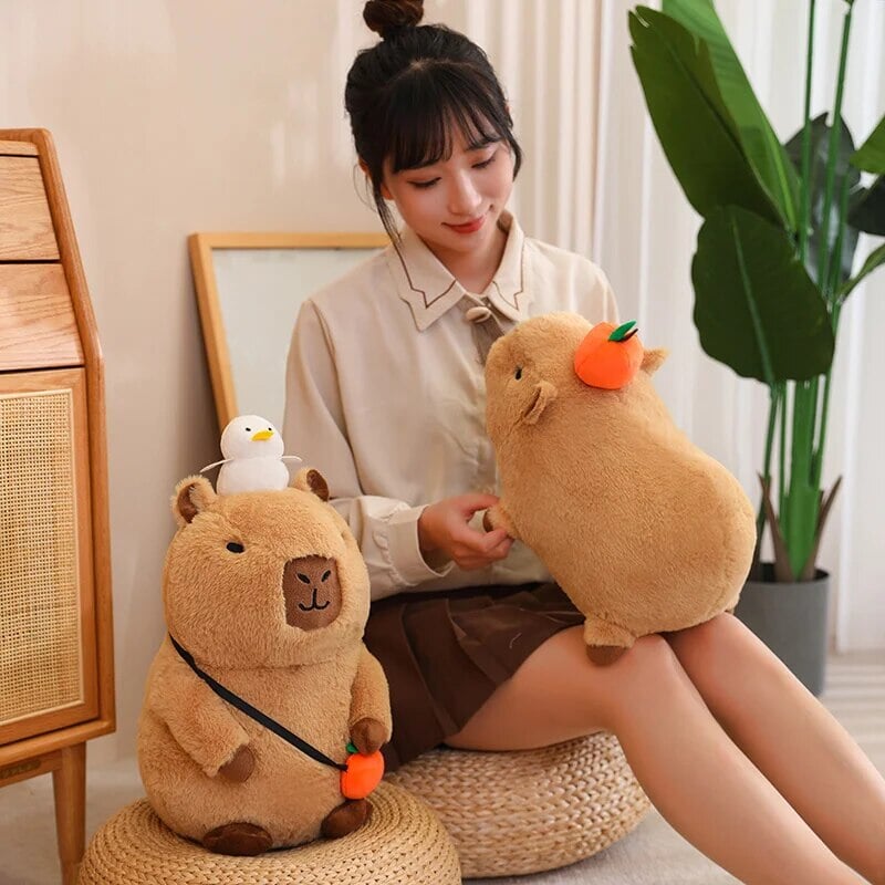 Skanto | Fluffy Sleepy Capybara med oransj kosedyr