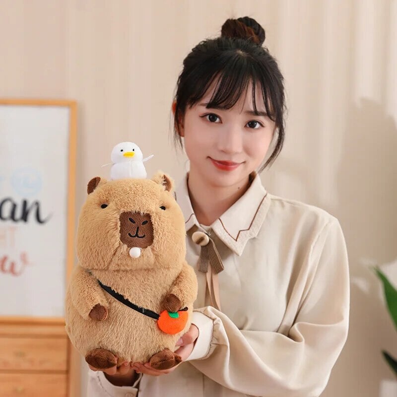 Skanto | Fluffy Sleepy Capybara med oransj kosedyr